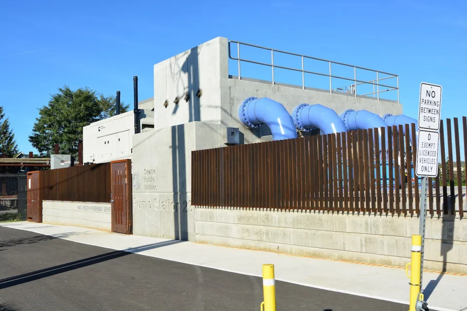 Pump station with blue pipes coming out of concrete wall in Seattle, Washington.